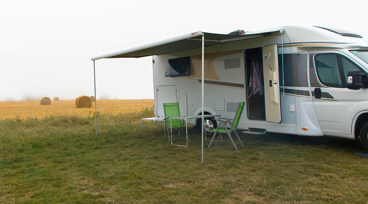 Motorhome with awning and dining chairs and table setup